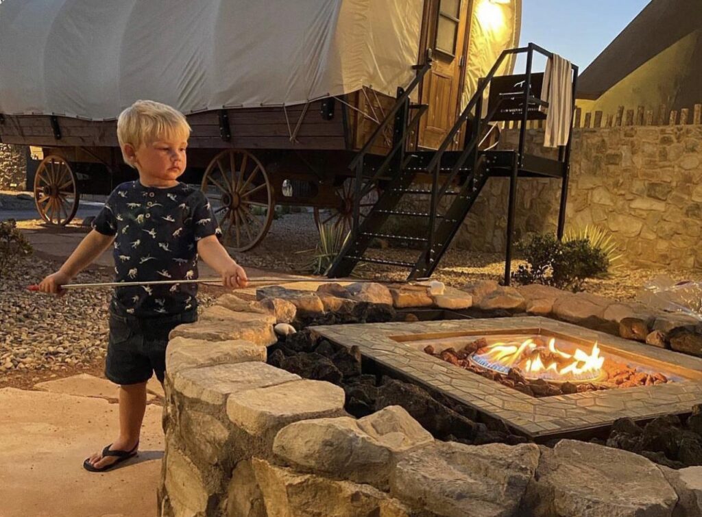 Child roasting marshmallow over open fire