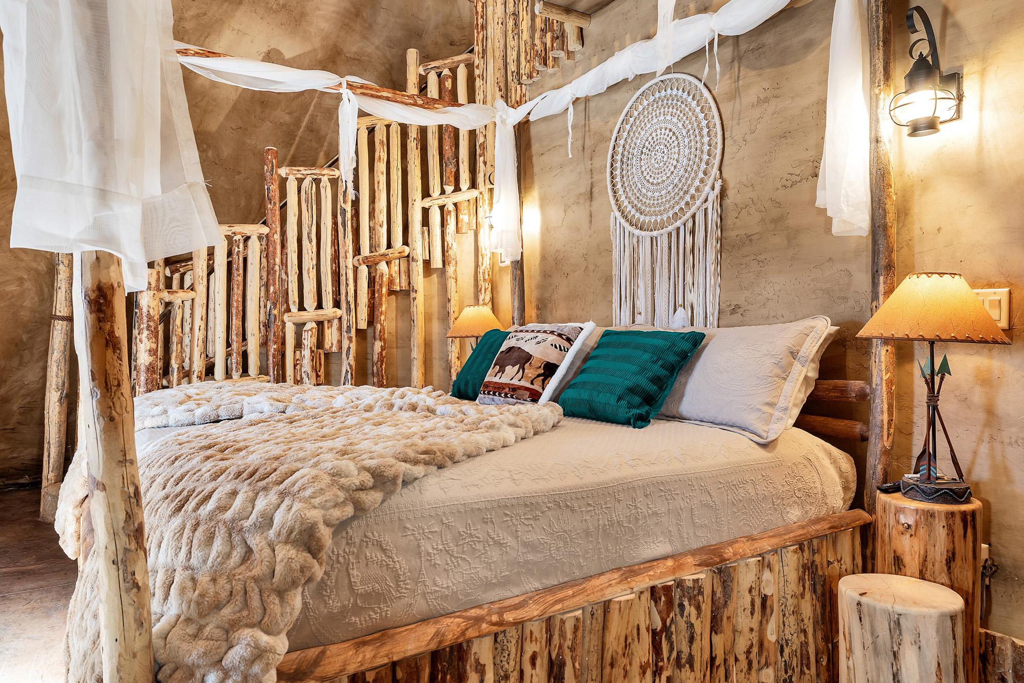 Interior of luxury teepee with king bed and teal pillows on top