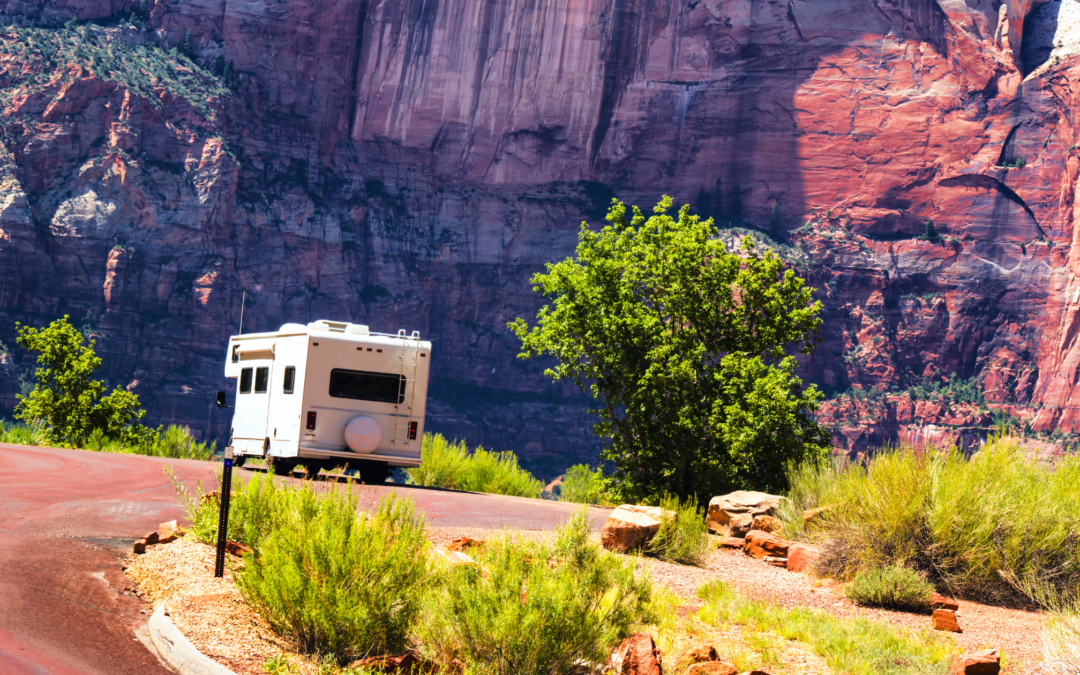 RV parked in front of sunlit rock formations of Zion National Park