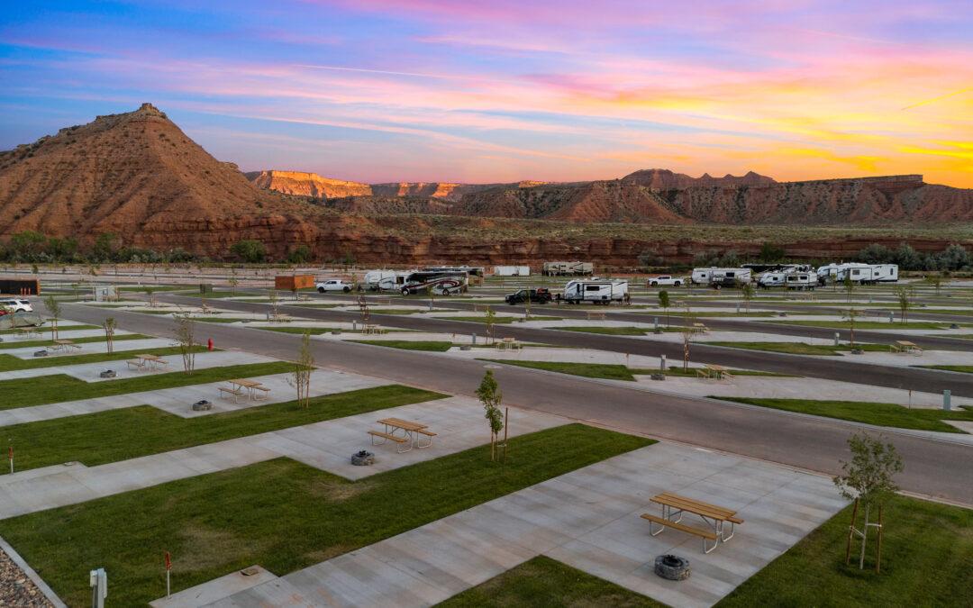 RV sites with paved roads and grassy areas at Zion White Bison Resort during sunset.