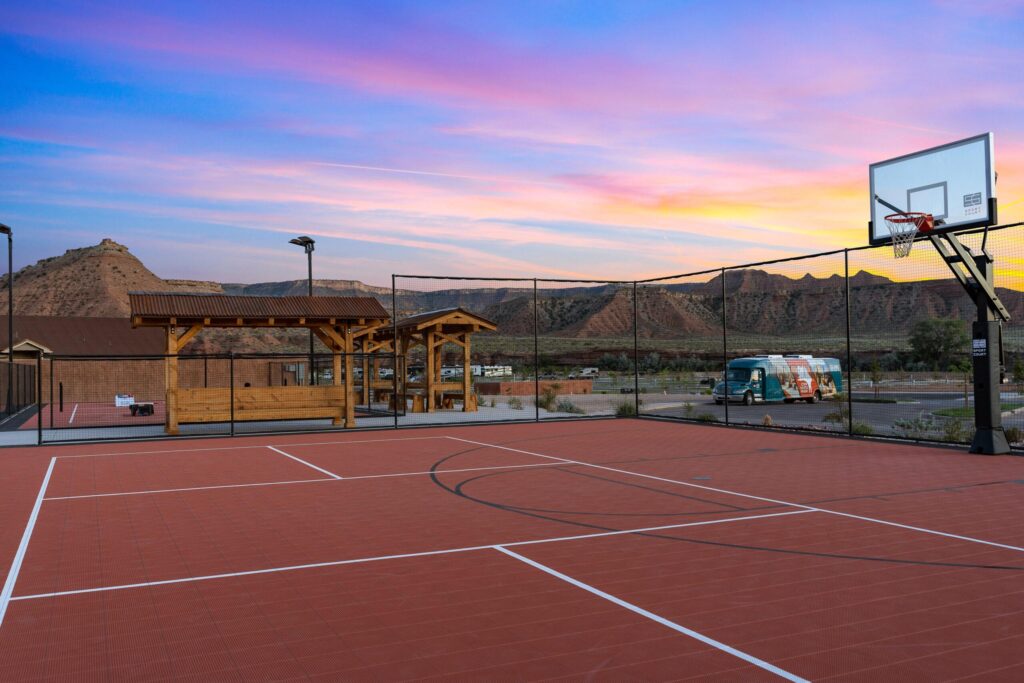Outdoor basketball court at Zion White Bison Resort during sunset.